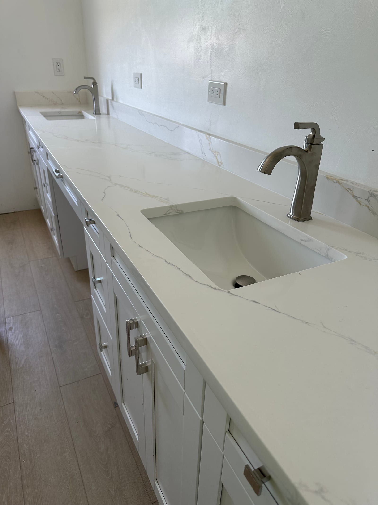Custom bathroom vanity with quartz countertop and brushed nickel pull-out faucet installed by Carter Backflow & Plumbing