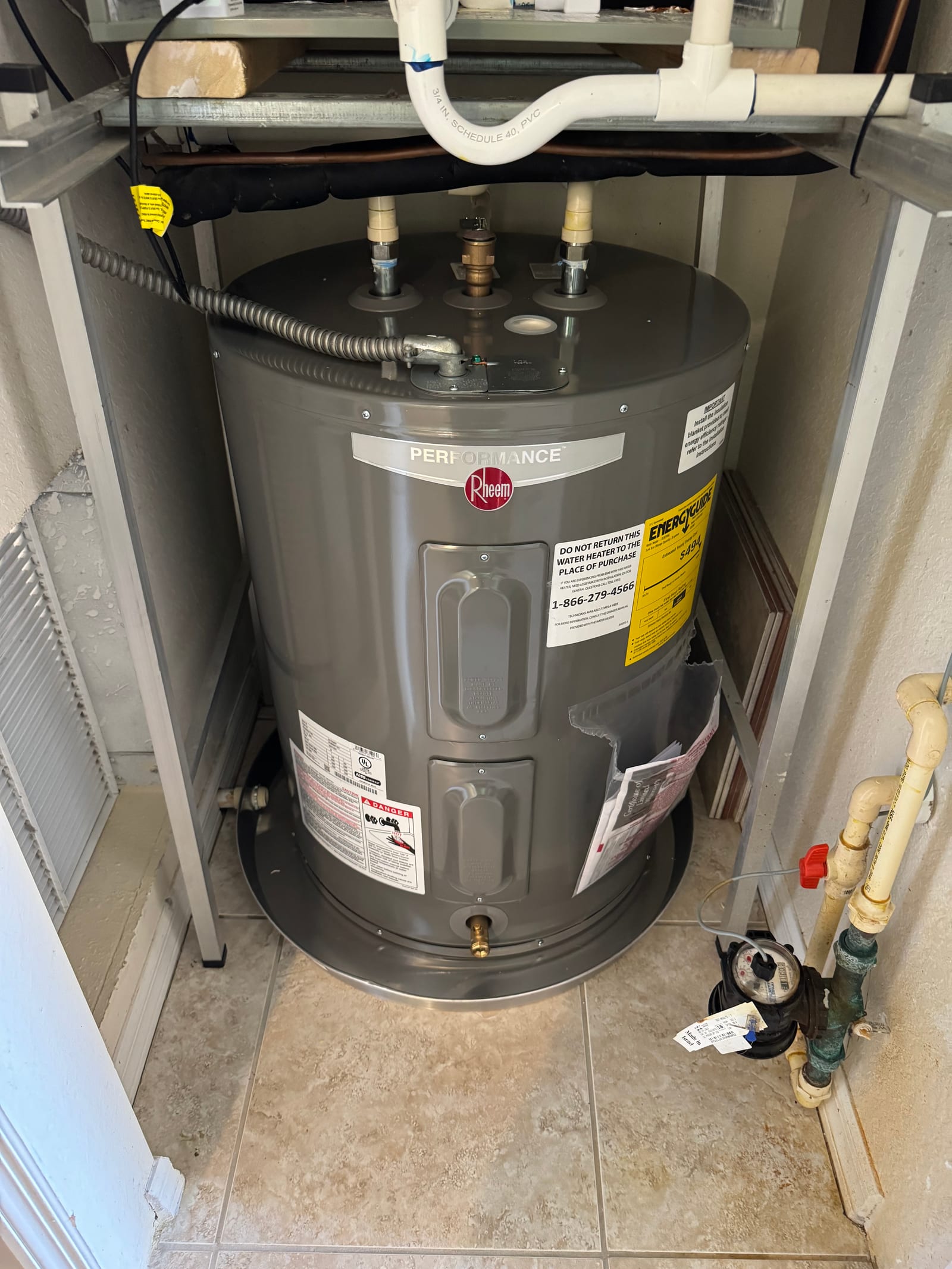 Newly installed Rheem Performance electric water heater with copper supply lines and shutoff valve